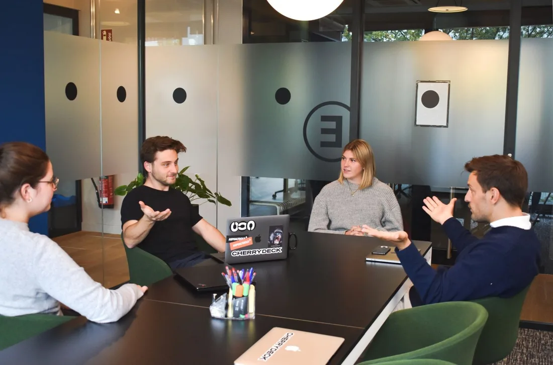 Four people talking around a meeting-room table